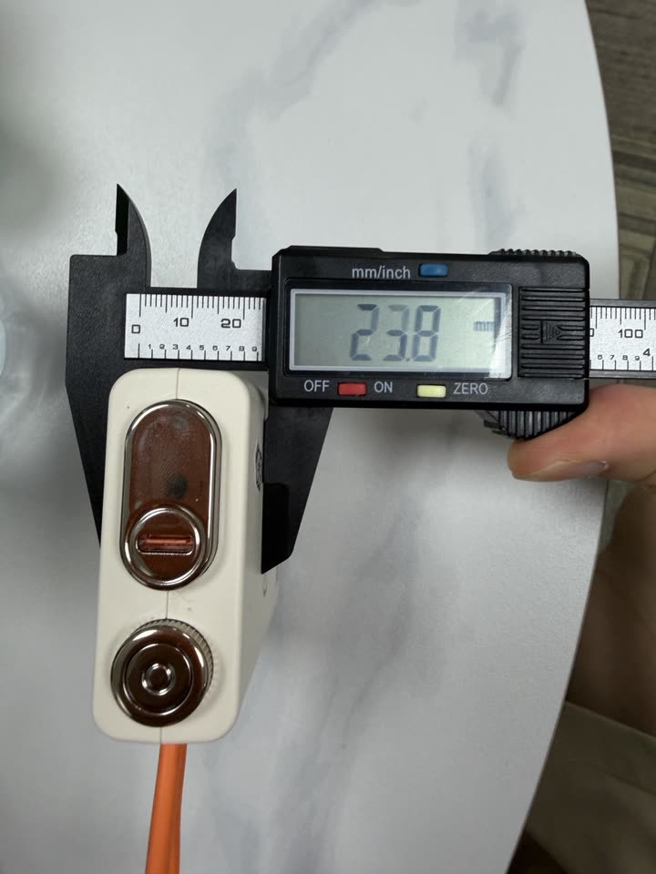 Caliper photo measuring the power bank depth at 23.8 millimetres