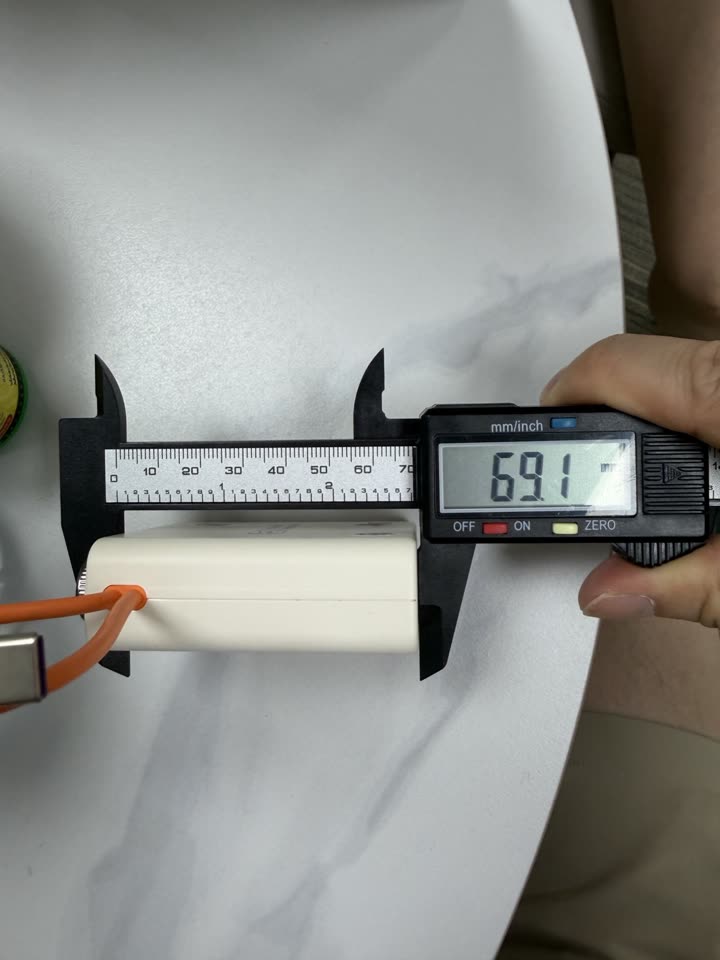 Caliper photo measuring the power bank height at 69.1 millimetres